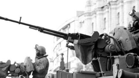 Adult man with gun in war battle black and white