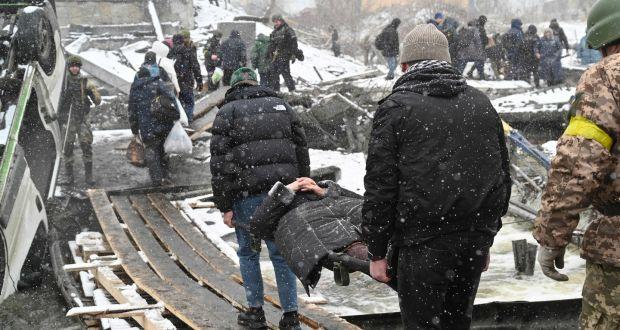 People carry a wounded woman during the evacuation of Irpin, Ukraine